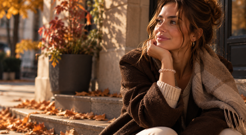 Frau mit Natursteinarmband von AVRE Studios in herbstlicher Stadtatmosphäre.