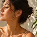 Nahaufnahme einer stilvollen Frau mit goldfarbenen Zirkonia-Ohrringen von AVRE Studios in warmer Sommerlichtstimmung. Das elegante Portrait setzt die funkelnden Ohrringe dezent in Szene und vermittelt moderne, feminine Leichtigkeit.
