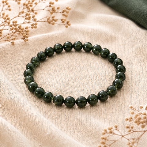 Green Sandstone Natursteinarmband mit 8 mm großen, glänzenden dunkelgrünen Perlen auf beigefarbenem Leinen, ergänzt durch Trockenblumen und einen dezenten dunkelgrünen Stoffakzent.
