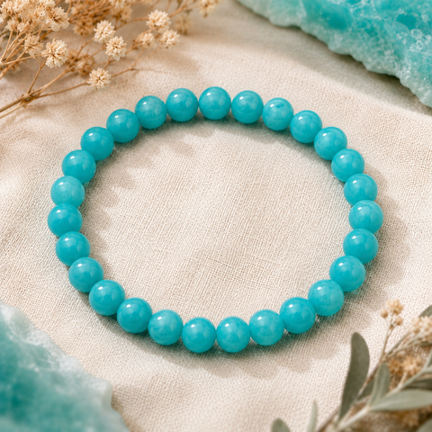 Lake Blue Jade Armband mit 8 mm großen, leicht marmorierten und gefärbten Perlen in Türkisblau auf hellem Naturstoff mit dezenten Blumen und farblich passenden Akzenten.