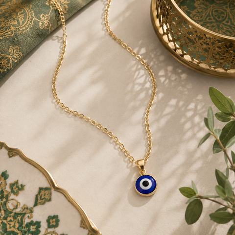 Goldene Nazar Halskette mit klassischem dunkelblauem Nazar Auge Anhänger auf luxuriösem beige-grünem Hintergrund mit orientalischen Details und warmen Lichtreflexen.