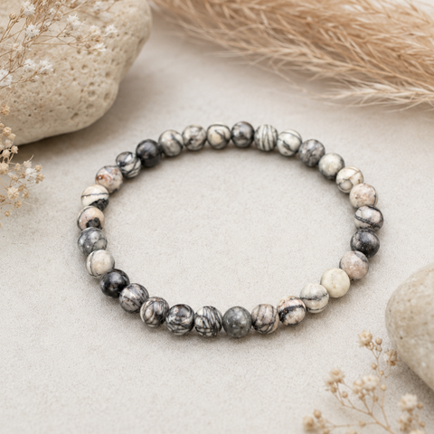 Svalbard Jasper Natursteinarmband mit 6 mm großen, individuell gemusterten Perlen in Creme-, Grau- und Schwarztönen.