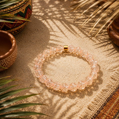 Aprikotfarbenes Bergkristall-Armband mit 8 mm großen Perlen im Diamantschliff auf warmem Untergrund, südamerikanisch inspiriert mit Palmensch Schatten und Naturdetails.