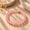 Atacama Bergkristall-Armband mit facettierten apricotfarbenen Perlen auf warmem beigefarbenem Hintergrund.
