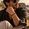 Mann trägt das Atacama Tigerauge Armband mit 8-mm-Perlen in warmer mediterraner Outdoor-Atmosphäre.