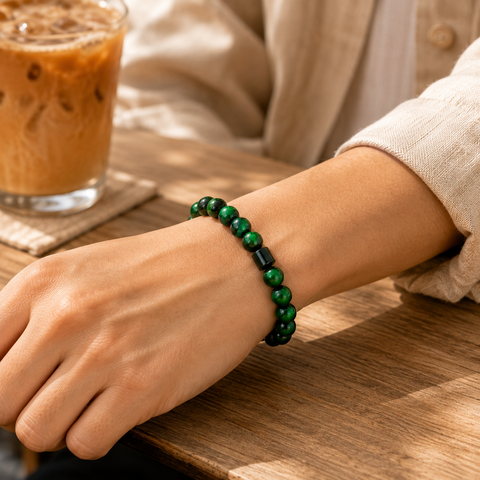 Grünes Tigerauge-Armband mit 8-mm-Perlen am Handgelenk in einer natürlichen Café-Szene mit warmem Sonnenlicht.