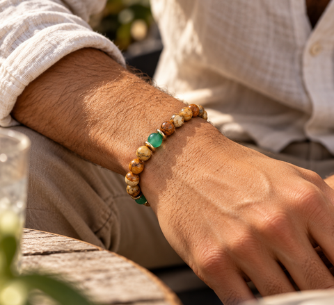 Mann trägt das KUNENE Aventurin & Landschaftsjaspis Armband mit grünen Aventurin- und braun-beigen Jaspisperlen am Handgelenk.