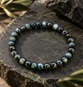 Lofoten Tigerauge Armband mit blauen 6-mm-Perlen in Dunkelblau, Petrol und Schwarz auf dunklem Naturstein.