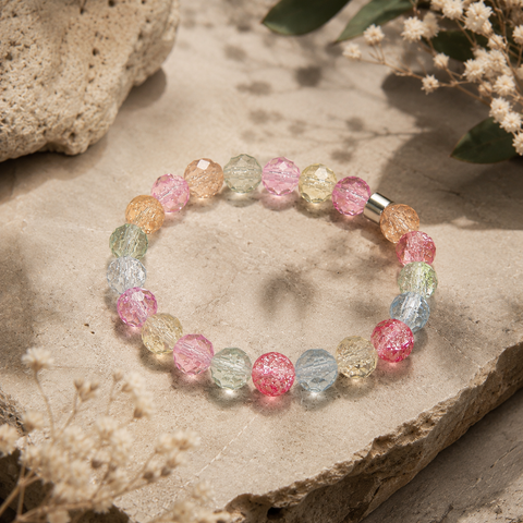Pastellfarbenes Kristallarmband mit facettierten 8-mm-Perlen in Rosa, Blau, Grün und Apricot auf hellem Naturstein.