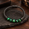 VERO Armband mit glänzenden grünen Tigerauge-Perlen und schwarzem geflochtenem Band.