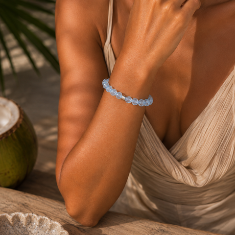 Hellblaues Bergkristall-Armband mit 8 mm großen Perlen im Diamantschliff am gebräunten Handgelenk getragen, inszeniert in warmer südamerikanischer Atmosphäre.