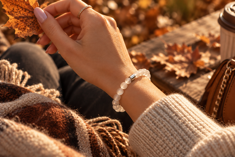 Frau trägt das Naxos Selenit Armband von AVRE Studios in warmer herbstlicher Atmosphäre.